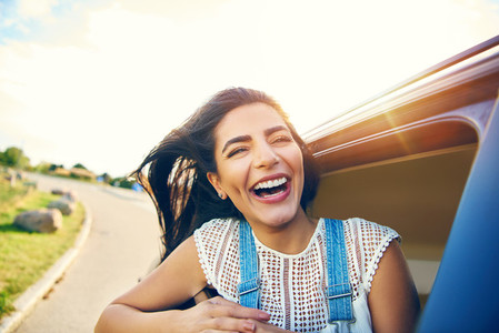 Cheerful young woman with brown hair in car