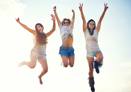 Three agile energetic teenagers leaping in the air