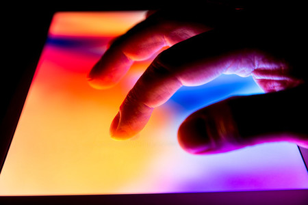 Hand using touch screen tablet business computer night