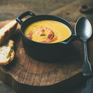Corn creamy soup with shrimps served in pot square crop
