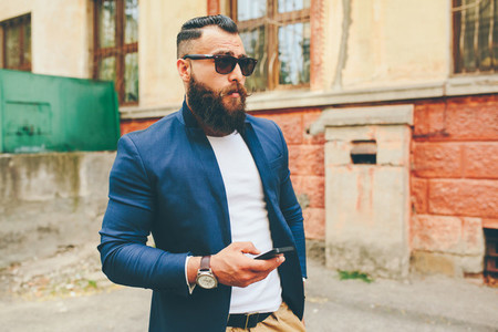 Bearded businessman looking at phone