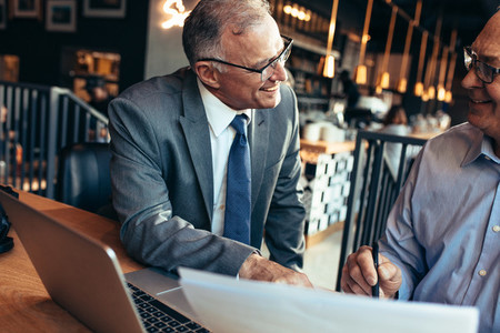 Senior businessmen meeting in a modern coffee shop
