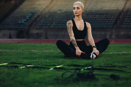 Female runner doing workout sitting in a stadium