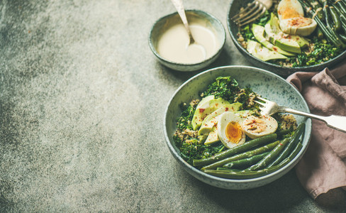Healthy vegetarian breakfast bowls over grey concrete background  selective focus