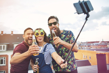 Group of three adults drinking and taking pictures