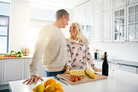 Senior man and woman at kitchen counter with food