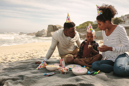 Family celebrating birthday of their son at the beach