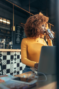 Female freelancer drinking chocolate shake at a coffee shop
