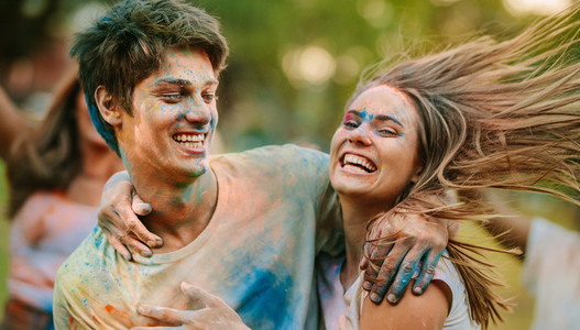Happy couple playing holi together and having fun