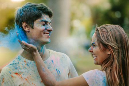 Couple playing holi in a park