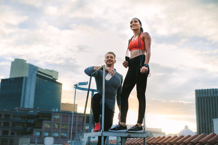 Fitness couple standing on rooftop of a building