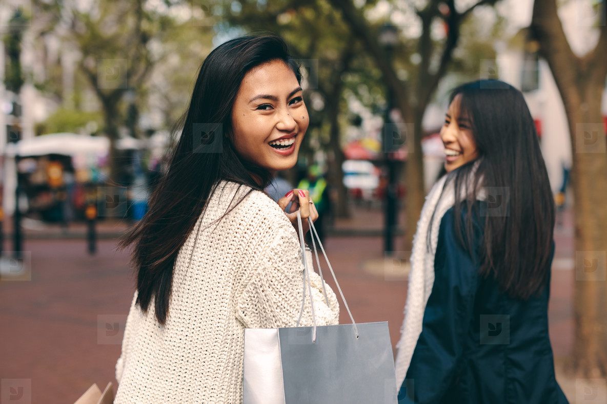 Smiling women walking around the city shopping