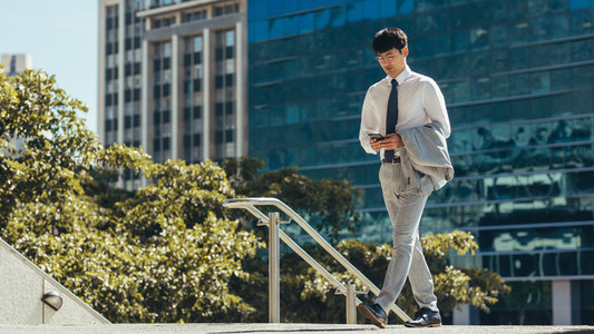 Businessman walking and using a smart phone outdoor