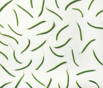 Flat lay of fresh green beans over white wooden background