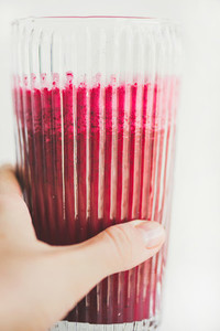 Fresh detox beetroot smoothie in glass in female hand