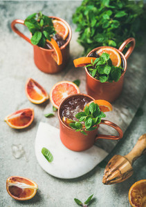 Blood orange Moscow mule alcohol cocktails over concrete background