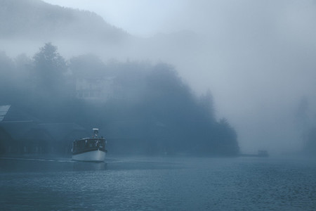 Views of lonely boat in the mist on the Konigsee lake of Germany