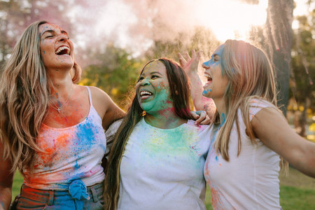 Women friends playing holi in a park