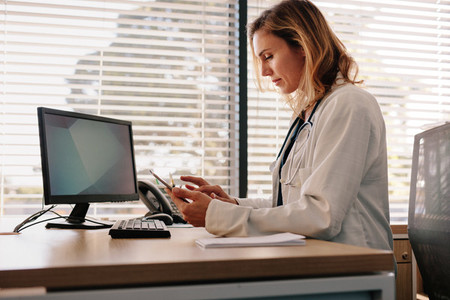 Female physician using a digital tablet in the clinic