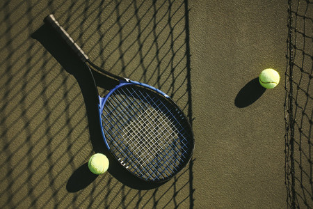 Top view of a tennis racket and tennis balls