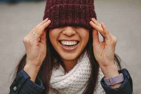 Portrait of a smiling woman with her face covered with a winter