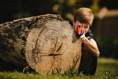 Boy playing with a toy gun outdoors