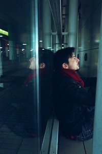 Young man alone in a bus station at night