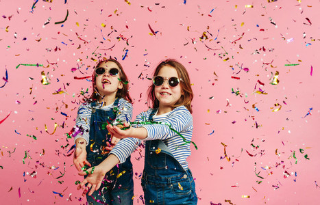 Girl twins playing with confetti