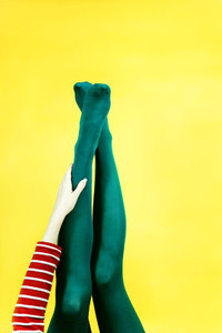 Pop art piece of young woman legs in tights against a yellow bac