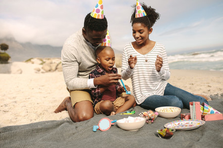 Family celebrating sons birthday on beach