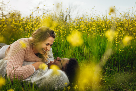 Smiling couple lying on meadow outdoors