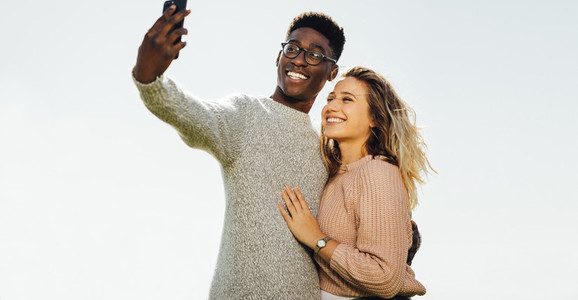 Interracial couple on holiday taking selfie