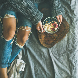 Woman in sweater and jeans eating rice porridge  square crop