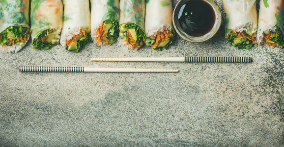 Vegan spring rice paper rolls over concrete background  copy space