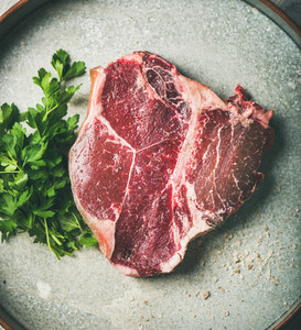 Flat lay of raw uncooked dry aged t bone prime beef steak
