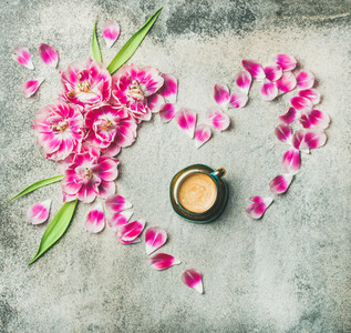 Cup of coffee  pink tulip flowers and petals