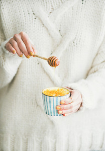 Healthy Turmeric Latte with Honey in females hands