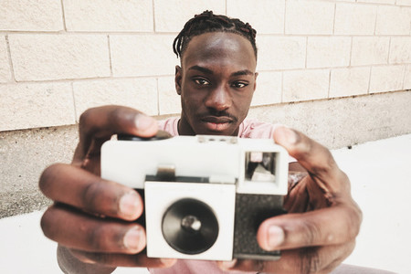 Young man holding an old analog camera