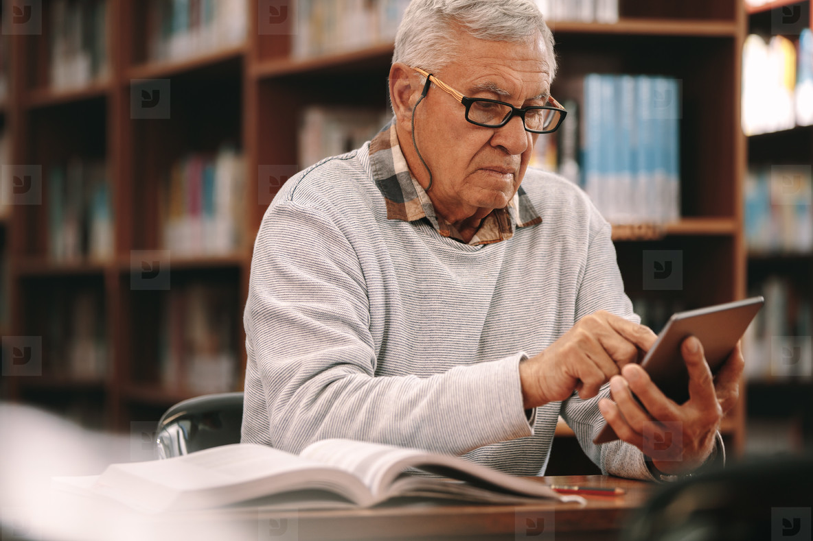 Senior man reading in a library