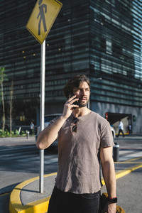 Contemporary adult man speaking on phone on street