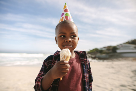 Birthday boy having ice cream on beach