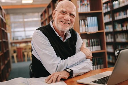Portrait of a smiling senior man sitting in a library