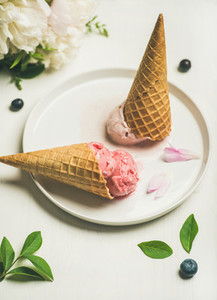 Ice cream scoops and peonies over white background  selective focus