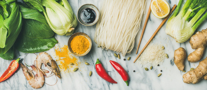 Flat lay of Asian cuisine ingredients over grey marble background