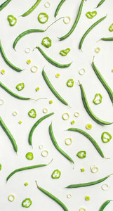 Flat lay of fresh green beans over white background  top view