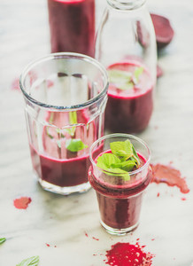 Fresh morning beetroot smoothie with mint in glass and bottle