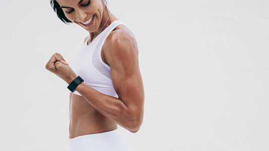 Close up of a smiling fitness woman looking at her hand