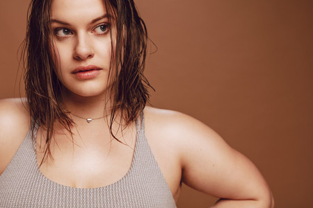 Oversized young woman against brown background
