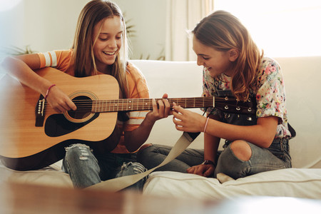 Girls learning to play guitar