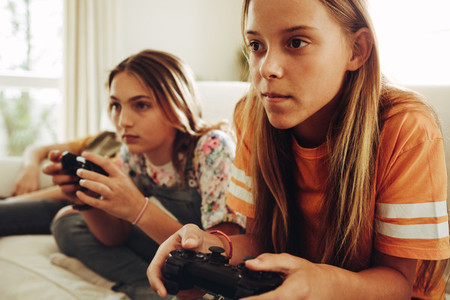 Girls playing video games at home